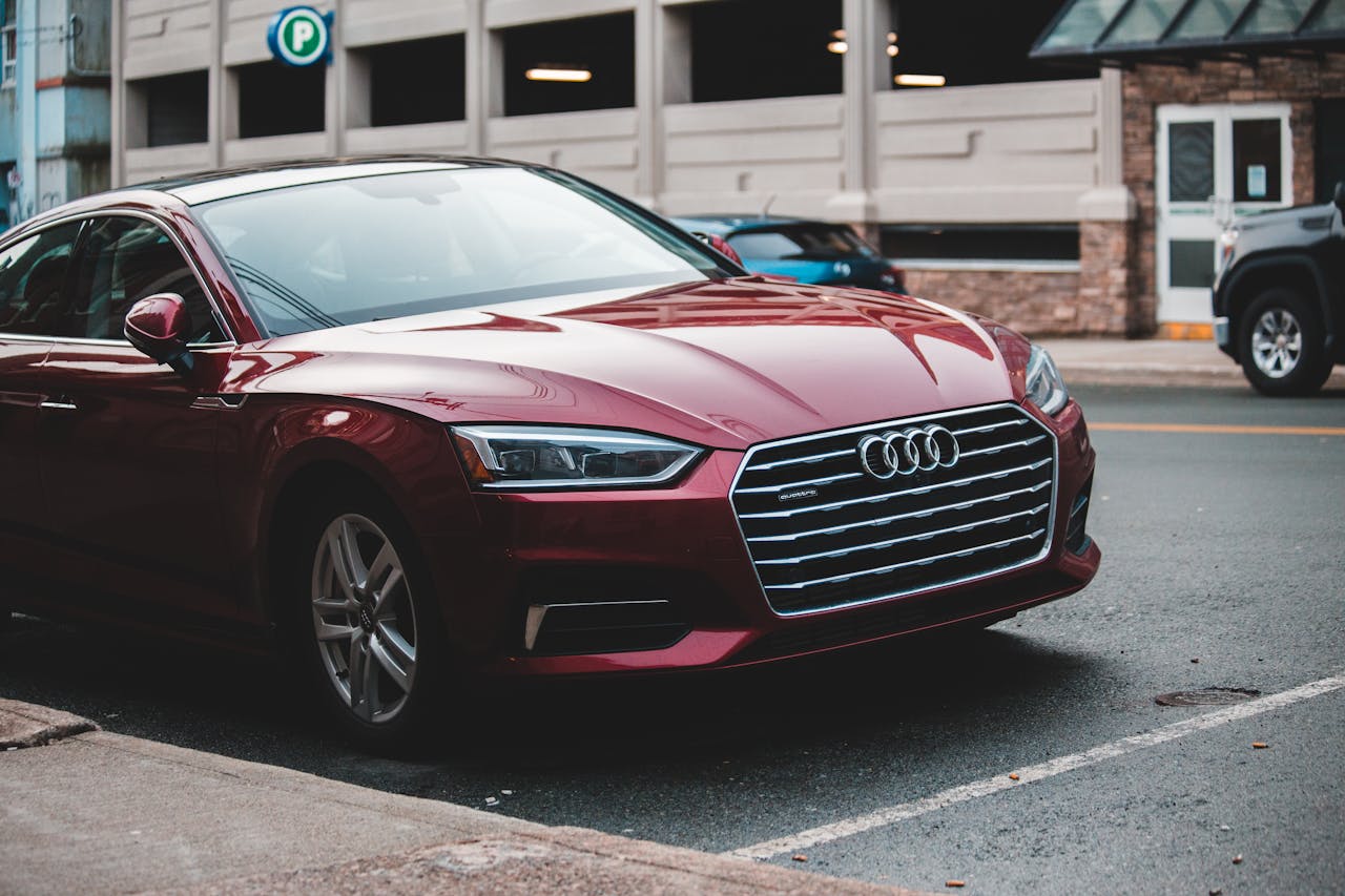 Modern luxury red automobile parked on asphalt road on city street in daylight